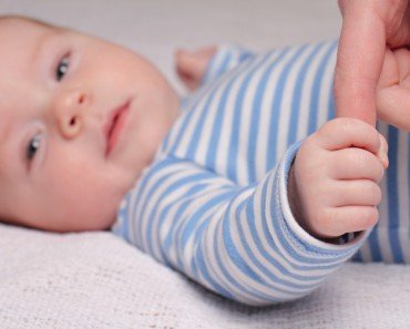 Baby fist holding finger