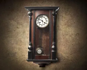 Old wooden pendulum hanging on a wall