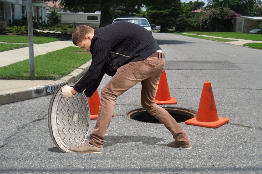 man-moving-manhole-cover