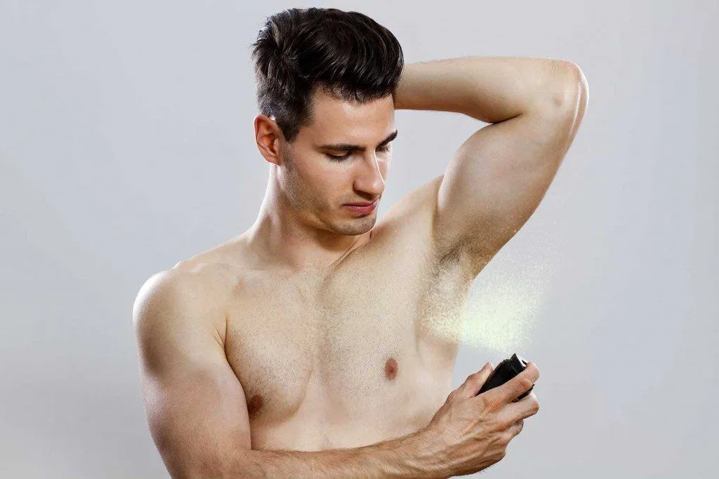 Handsome man spraying deodrant (InesBazdar)(s)