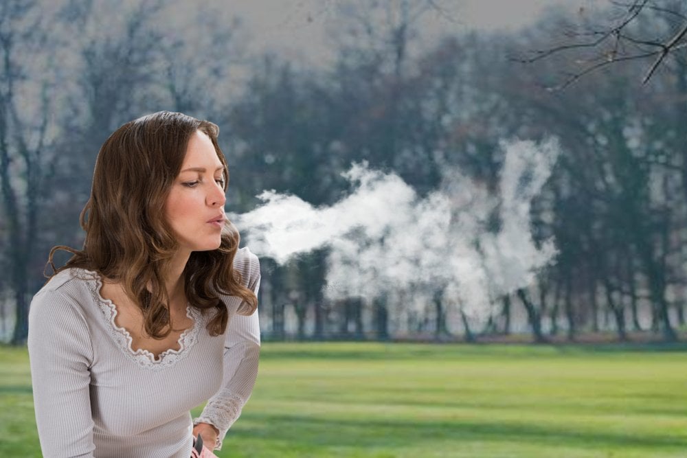 Young Woman blowing breath cloud