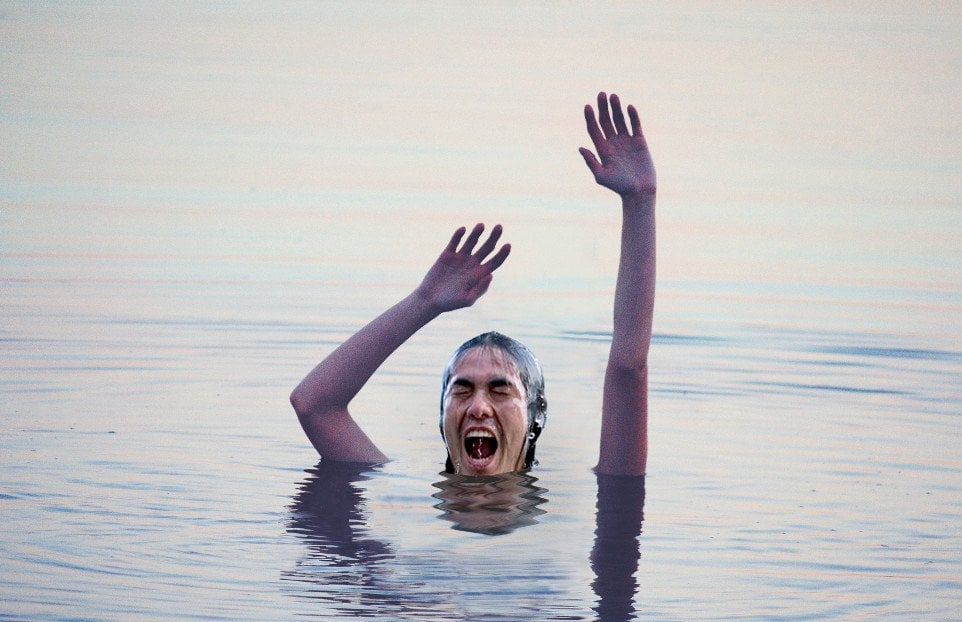Boy waving arms in water for help