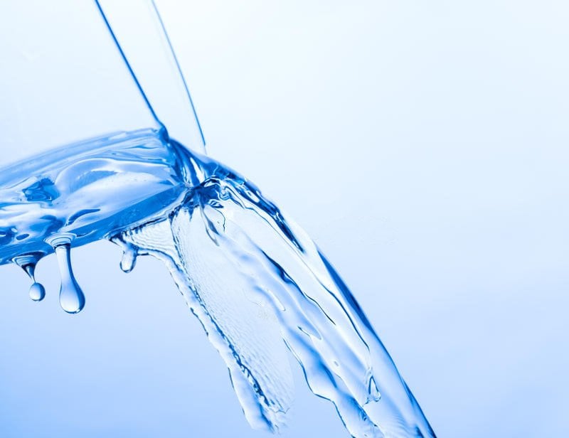 Liquid pouring while sticking to the side of the container