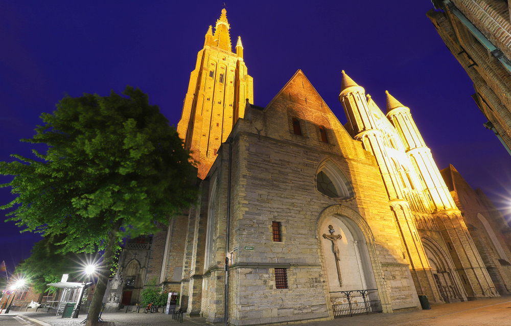 Night view of a typical street of historic Bruges, with Onze-Lieve-Vrouwekerk-Church of Our Lady as background, Belgium - Image( Petr Kovalenkov)s