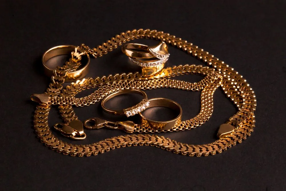 Various gold jewelry, chaotically arranged wedding rings, engagement ring, chain, bracelet. Isolated on a matte black background(Dumitru Ochievschi)s