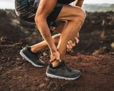 Achilles injury on running outdoors. Man holding Achilles tendon by hands close-up and suffering with pain( Breslavtsev Oleg)s