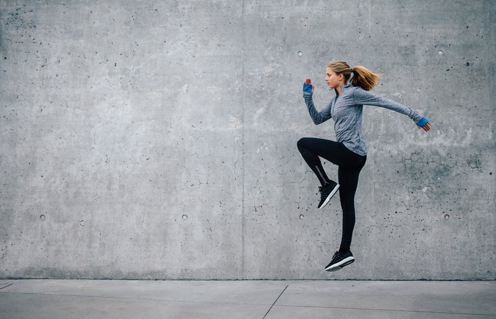 Side view shot of fit young woman doing cardio interval training against grey background( Jacob Lund)S