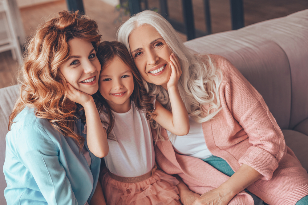 portrait of family of three generations sitting on the sofa and looking at the camera(AT Production)S