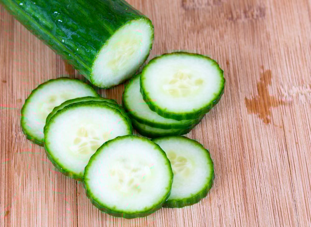 Sliced seedless cucumber over a wooden cutting board(BobNoah)S