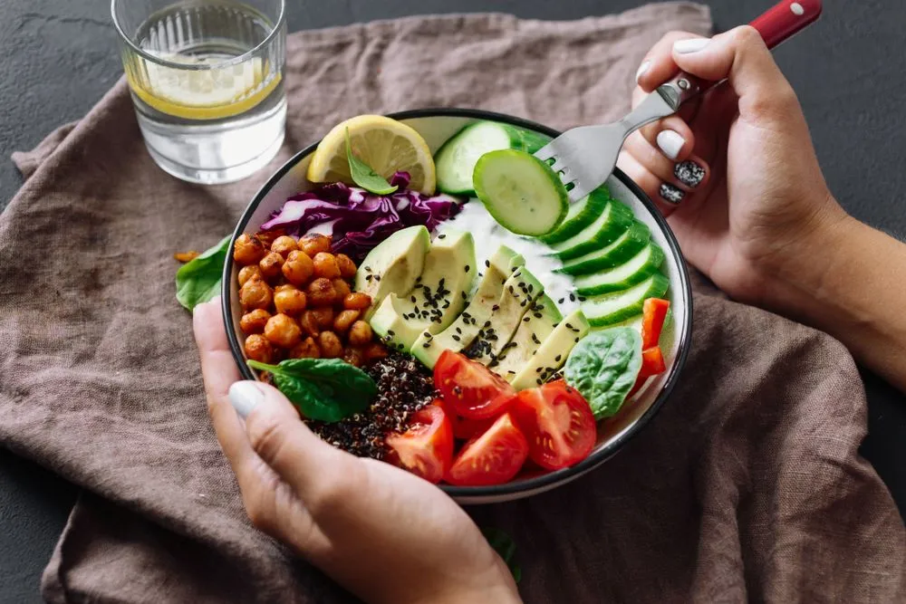 Woman is eating healthy lunch on dark background(Anna Kucher)s