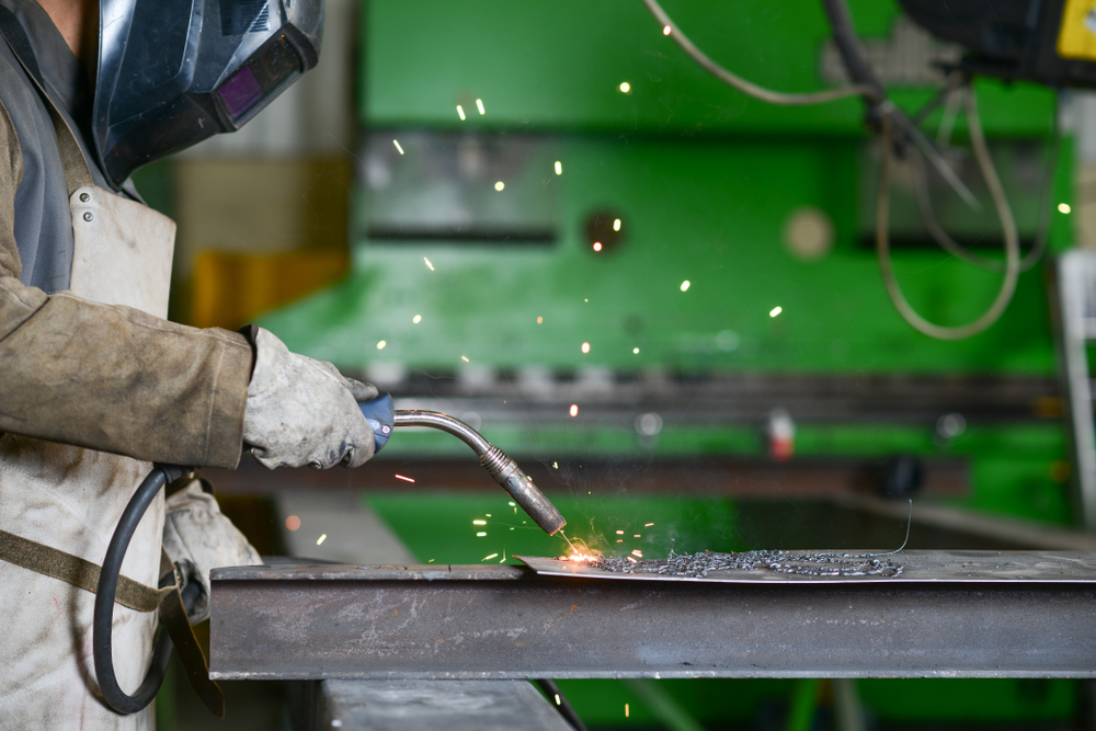 handsome man workshop welding iron spark fire hot steel with power GMAW welder and protective gear(JP WALLET)s