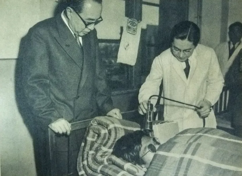 A doctor inspecting the amount of radiation sickness one of the crew members of the boat has. One of the symptoms of radiation sickness is the falling out of hair (Photo Credit: Wikimedia)
