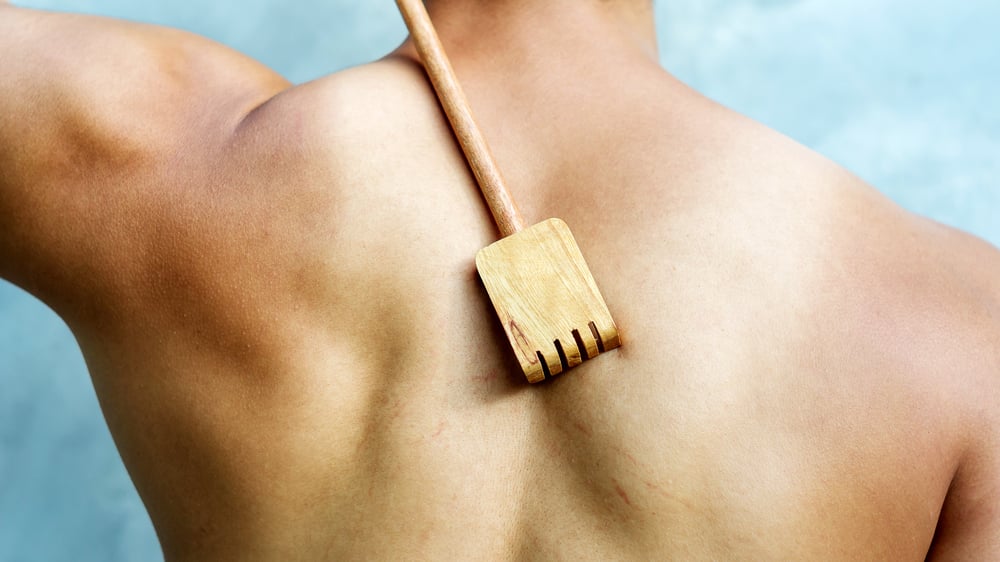 Man scratching his back with a wooden backscratcher(Supaleka_P)s