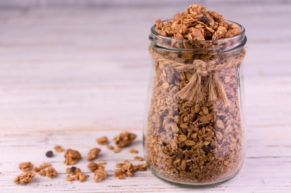 Healthy,Breakfast,Homemade,Granola,In,Glass,Jar,On,White,Wooden