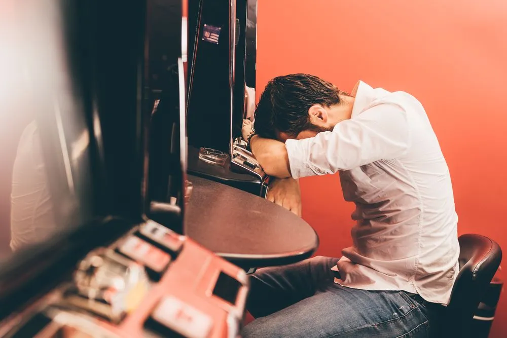 Man,Losing,At,Slot,Machines,In,Casino
