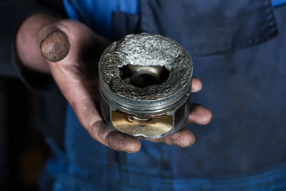 Car,Mechanic,Hand,With,Damaged,Engine,Valve,Piston,At,Repair