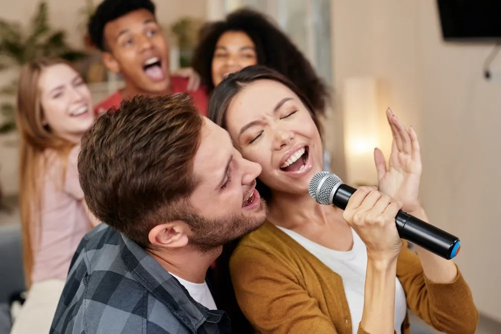 Sing,Together.,Young,Excited,Couple,Or,Friends,Holding,Microphone,And