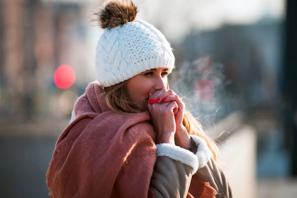 Woman,Breathing,On,Her,Hands,To,Keep,Them,Warm,At