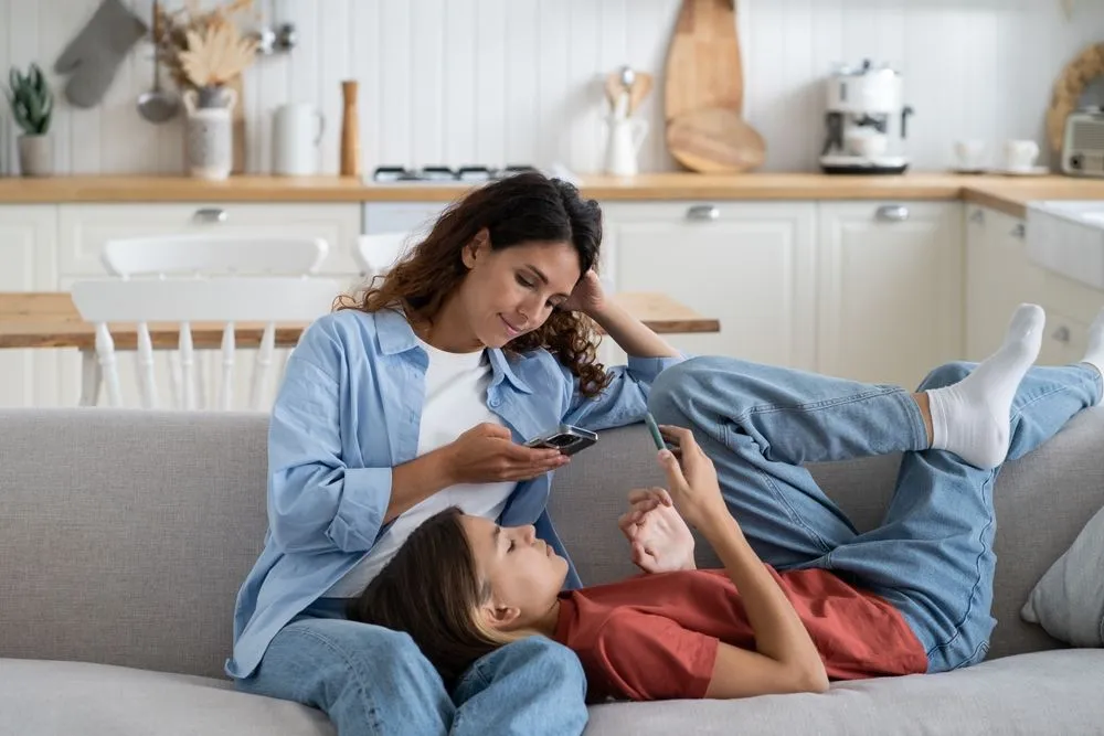 Young,Modern,Family,Mother,And,Teen,Daughter,Busy,With,Gadgets