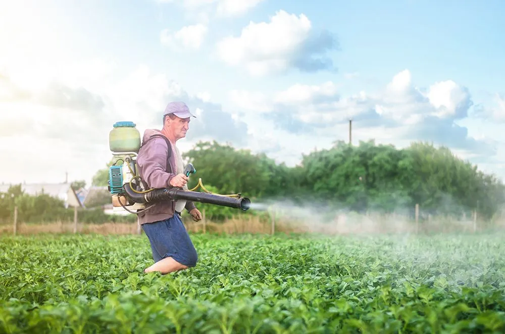 A farmer sprays a solution of copper sulphate (Credits: ilixe/Freepik)
