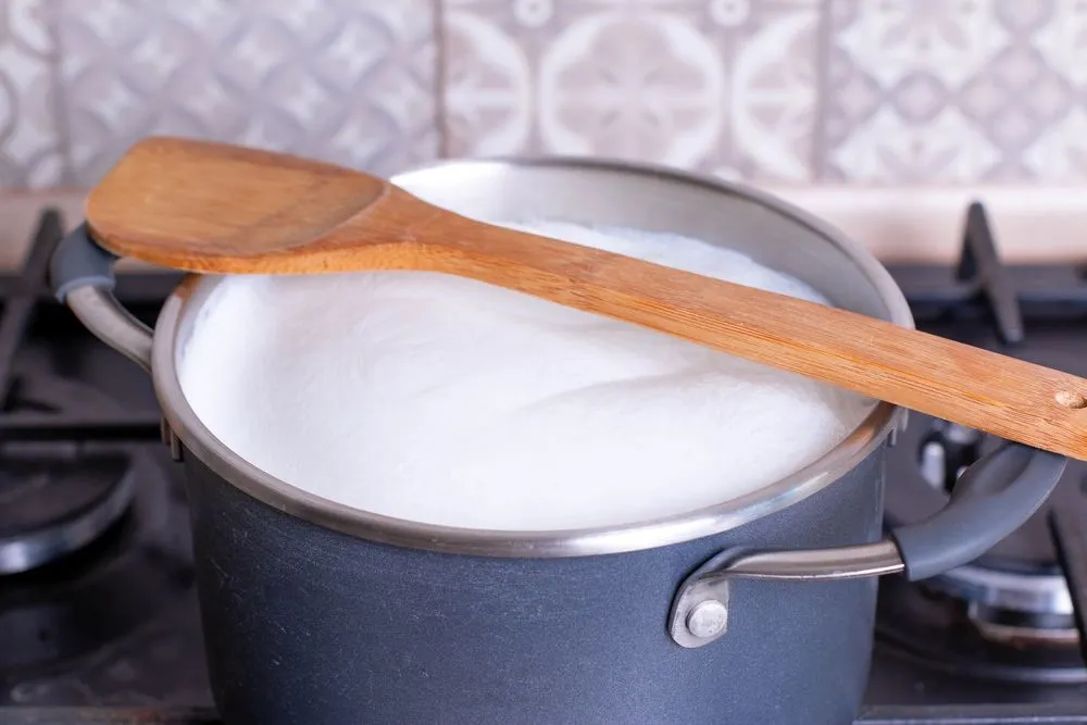 Keeping a ladle on top of the vessel is a way to keep milk from temporarily spilling over. This happens by allowing a path for the vapors to escape. (Credits: Ahanov Michael/Shutterstock)