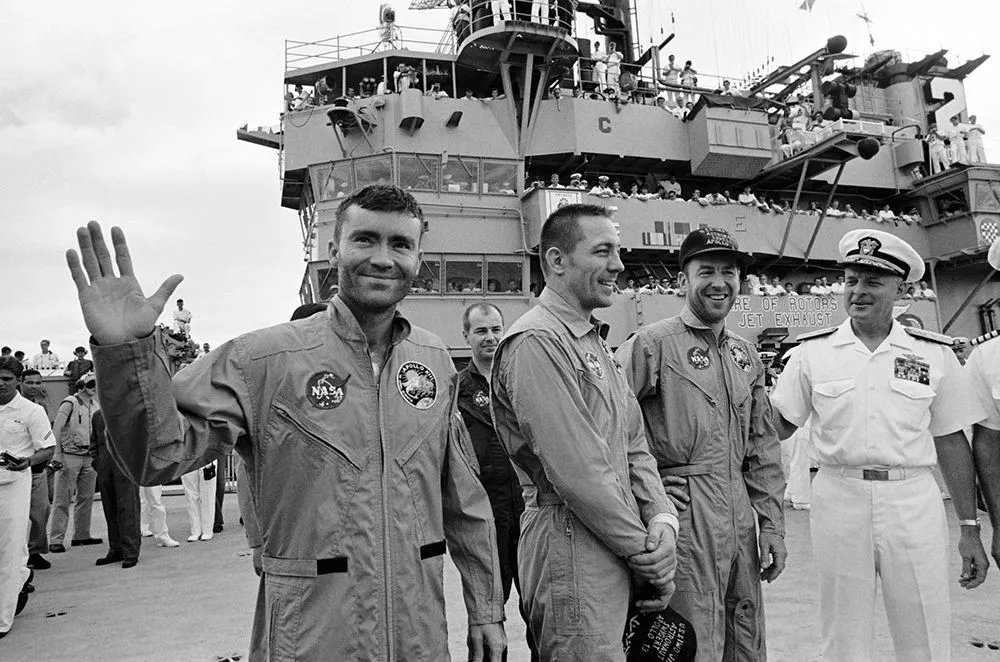 This is the photograph of the Apollo 13 crew when they were rescued after landing in the Pacific Ocean. From left to right: Fred Haise (waving), John Swigert and James Lovell. (Credits: NASA)